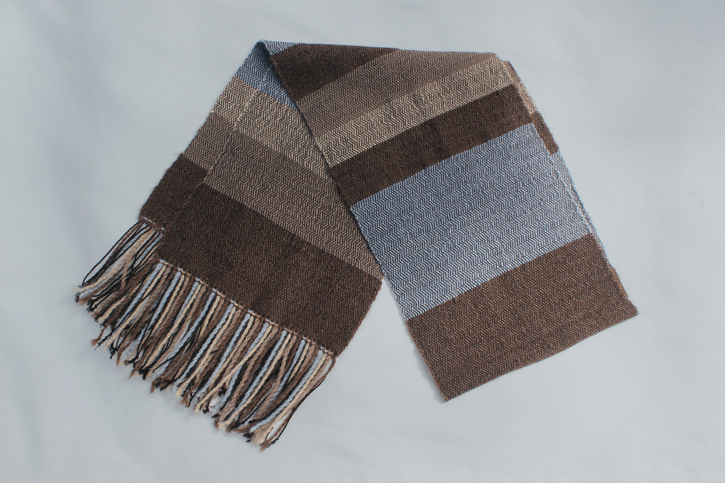 Folded in half alpaca and cotton herringbone striped blue, beige and brown scarf.
